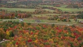 5.5K aerial stock footage flying over colorful forest in autumn, approaching farms, Turner, Maine Aerial Stock Footage | AX150_040