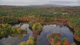 5.5K aerial stock footage flying over Nezinscot River, approach colorful forest, autumn, Turner, Maine Aerial Stock Footage | AX150_052