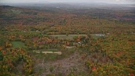 5.5K aerial stock footage flying over colorful forest, tilt up, reveal rural residential area, autumn, Paris, Maine Aerial Stock Footage | AX150_073E