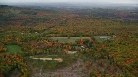 5.5K aerial stock footage flying over rural homes, approaching colorful forest, autumn, Paris, Maine Aerial Stock Footage | AX150_074
