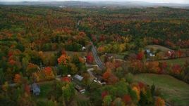 5.5K aerial stock footage flying over colorful forest, rural homes, Buckfield Road, autumn, Paris, Maine Aerial Stock Footage | AX150_075