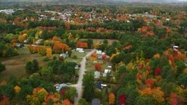 5.5K aerial stock footage flying over rural homes, colorful trees, tilt up to reveal small town, autumn, Paris, Maine Aerial Stock Footage | AX150_082