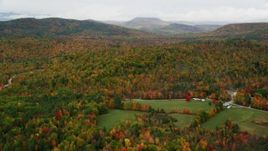 5.5K aerial stock footage flying over a brightly colored forest in autumn, overcast, Waterford, Maine Aerial Stock Footage | AX150_114