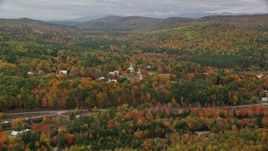 5.5K aerial stock footage approaching small rural town, brightly colored forest, autumn, Waterford, Maine Aerial Stock Footage | AX150_116E