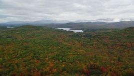 5.5K aerial stock footage flying over colorful forest, approach Cezar Lake, autumn, overcast, Lovell, Maine Aerial Stock Footage | AX150_135
