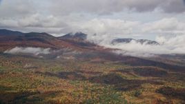 5.5K aerial stock footage flying over colorful forest, autumn, by clouds, White Mountains, New Hampshire Aerial Stock Footage | AX150_149E