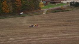 5.5K aerial stock footage tracking a tractor on farmland, colorful trees in autumn, Woodsville, New Hampshire Aerial Stock Footage | AX150_291