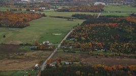 5.5K aerial stock footage flying by rural farms, Airport Road, colorful trees, autumn, overcast, Barre, Vermont Aerial Stock Footage | AX150_399