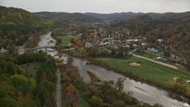 5.5K aerial stock footage flying by small bridge, White River, small rural town, autumn, South Royalton, Vermont Aerial Stock Footage | AX150_428E