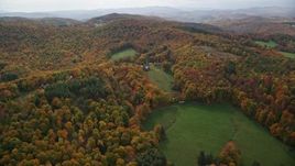 5.5K aerial stock footage flying over colorful forest, hills, approach rural home, tilt down, autumn, North Pomfret, Vermont Aerial Stock Footage | AX150_460