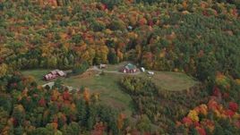 5.5K aerial stock footage flying by small farm, grassy clearings and colorful trees, autumn, Quechee, Vermont Aerial Stock Footage | AX150_470