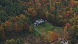 5.5K aerial stock footage flying by rural homes, lawns, brightly colored trees in autumn, Quechee, Vermont Aerial Stock Footage | AX150_471