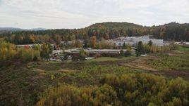5.5K aerial stock footage flying by office buildings, colorful foliage, cloudy skies, autumn, Lebanon, New Hampshire Aerial Stock Footage | AX150_476
