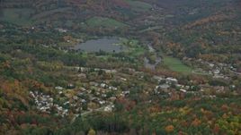 5.5K aerial stock footage flying by Lake Pinneo, nearby rural neighborhood, autumn, Quechee, Vermont Aerial Stock Footage | AX151_006