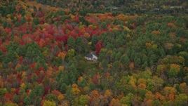5.5K aerial stock footage flying by rural home, dense colorful trees, tilt down, autumn, Quechee, Vermont Aerial Stock Footage | AX151_007