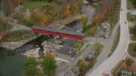 5.5K aerial stock footage flying over Ottauquechee River, approach covered bridge, small rural town, autumn, Taftsville, Vermont Aerial Stock Footage | AX151_031E