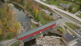 5.5K aerial stock footage approaching small rural town, reveal covered bridge, Ottauqueche River, autumn, Taftsville, Vermont Aerial Stock Footage | AX151_035E