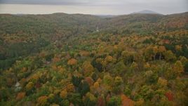 5.5K aerial stock footage flying over brightly colored forested hills, approach rural homes, autumn, Taftsville, Vermont Aerial Stock Footage | AX151_037E
