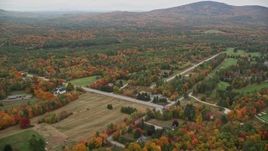 5.5K aerial stock footage flying over colorful forest, approach rural homes, autumn, New London, New Hampshire Aerial Stock Footage | AX151_105