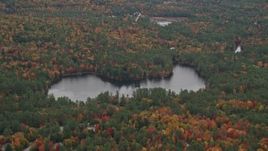 5.5K aerial stock footage flying by Chase Pond, waterfront homes, forest, autumn, Wilmot, New Hampshire Aerial Stock Footage | AX151_108