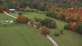 5.5K aerial stock footage flying by grassy clearings, red barn, colorful trees, autumn, Warner, New Hampshire Aerial Stock Footage | AX151_124