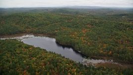 5.5K aerial stock footage flying over Trumbull Pond, forest in autumn, reveal Lake Winnepocket, Webster, New Hampshire Aerial Stock Footage | AX151_125E