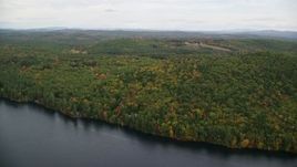 5.5K aerial stock footage flying over Lake Winnepocket, dense forest, rural homes in autumn, overcast, Webster, New Hampshire Aerial Stock Footage | AX151_127E