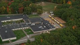 5.5K aerial stock footage orbiting Hooksett Memorial School, revealing buses, autumn, Hooksett, New Hampshire Aerial Stock Footage | AX152_026E