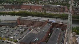 5.5K aerial stock footage flying by factory near bridge spanning river, autumn, Lawrence, Massachusetts Aerial Stock Footage | AX152_100E
