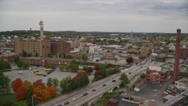 5.5K aerial stock footage fly over a bridge over Merrimack River and factories with smokestacks, approach parking gargage, autumn, Lawrence, Massachusetts Aerial Stock Footage | AX152_104E