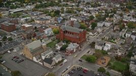 5.5K aerial stock footage flying over church in a town with partial fall foliage, autumn, Lawrence, Massachusetts Aerial Stock Footage | AX152_112