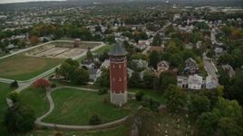 5.5K aerial stock footage orbiting away from a water tower and town with fall trees, autumn, Lawrence, Massachusetts Aerial Stock Footage | AX152_115E