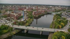 5.5K aerial stock footage flying over town and bridge spanning a river, approaching and orbit factory, Lowell, Massachusetts Aerial Stock Footage | AX152_127E