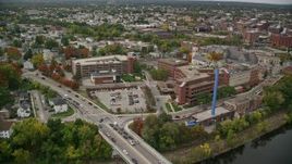 5.5K aerial stock footage orbiting Saints Medical Center and a blue smoke stack, near the river, autumn, Lowell, Massachusetts Aerial Stock Footage | AX152_132E