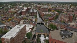 5.5K aerial stock footage flying over canal past factories toward locks and dam, autumn, Lowell, Massachusetts Aerial Stock Footage | AX152_134E