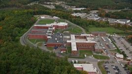 5.5K aerial stock footage orbiting away from a prison among trees, autumn, Billerica, Massachusetts Aerial Stock Footage | AX152_154E