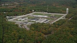 5.5K aerial stock footage flying away from Massachusetts Correctional Institution Cedar Junction and fall trees, autumn, Walpole, Massachusetts Aerial Stock Footage | AX152_216E