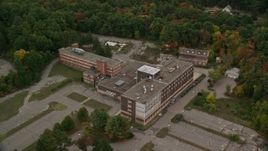 5.5K aerial stock footage orbiting away from an abandoned hospital among fall foliage, Walpole, Massachusetts Aerial Stock Footage | AX152_220E