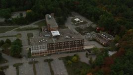 5.5K aerial stock footage orbiting away from an abandoned hospital surrounded by fall foliage, Walpole, Massachusetts Aerial Stock Footage | AX152_221