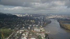 5.5K aerial stock footage flying over river looking toward downtown and low hanging clouds, Southwest Portland, Oregon Aerial Stock Footage | AX153_013