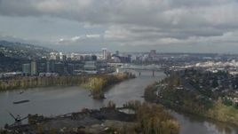 5.5K aerial stock footage flying over Willamette River with downtown in background, partly cloudy, autumn, Southwest Portland, Oregon Aerial Stock Footage | AX153_016