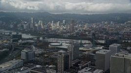 5.5K aerial stock footage flying over office buildings and high-rises with view of Downtown Portland with clouds, Oregon Aerial Stock Footage | AX153_023E