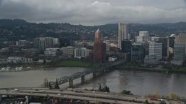 5.5K aerial stock footage flying by bridge along river with views of skyscrapers and high-rises, Downtown Portland, Oregon Aerial Stock Footage | AX153_034