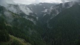 5.5K aerial stock footage following Eagle Creek Trail through a canyon with mist and forest in Cascade Range, Hood River County, Oregon Aerial Stock Footage | AX154_050