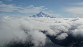 5.5K aerial stock footage flying over thick cloud layer to approach snowy Mount Hood, Cascade Range, Oregon Aerial Stock Footage | AX154_062E
