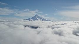 5.5K aerial stock footage of the snowy summit of Mount Hood above the clouds, Cascade Range, Oregon Aerial Stock Footage | AX154_065