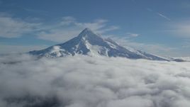 5.5K aerial stock footage flying over clouds to approach Mount Hood with snow, Mount Hood, Cascade Range, Oregon Aerial Stock Footage | AX154_071