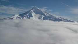 5.5K aerial stock footage flying over clouds to approach Mount Hood with snow, Mount Hood, Cascade Range, Oregon Aerial Stock Footage | AX154_073E
