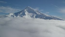 5.5K aerial stock footage of a slow approach to snowy Mount Hood, surrounded by clouds, Mount Hood, Cascade Range, Oregon Aerial Stock Footage | AX154_075