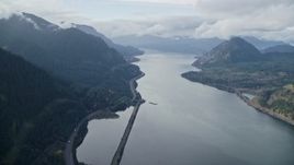 5.5K aerial stock footage approaching the I-84 highway at the base of mountains in Columbia River Gorge Aerial Stock Footage | AX154_156E